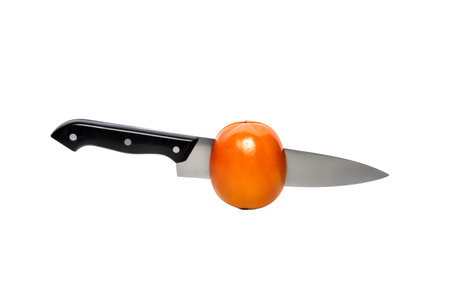 Persimmon wirh knife inside, cut in half. Isolated on a white background, with clipping path.の写真素材