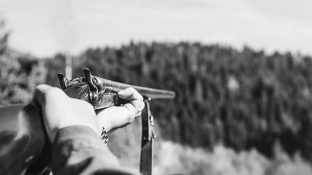 Hunter with retro shotgun aims at the target. Hunting season.の写真素材
