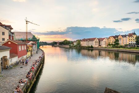 Regensburg, Germany - 26 July, 2018: People have rest on Danube River bank. Beautiful sunset. Popular tourist destinations in Regensburg.のeditorial素材