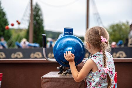 Loifling, Germany - 26 July, 2018: Little girl plays near toy cannon on Pirates of Caribbean attraction in Churpfalzpark Loifling. Rest and fun for everyoneのeditorial素材