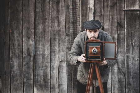 Photographer prepares for shooting on large format camera. Concept - photography of the 1930s-1950s, matte effectの写真素材