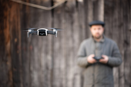 Old fashioned men from village mastering to fly drone, basics of remote control.