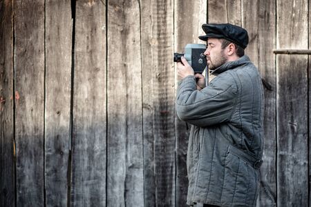 Cameraman with retro film camera. Idea - cinema industry, movie of 1970sの写真素材