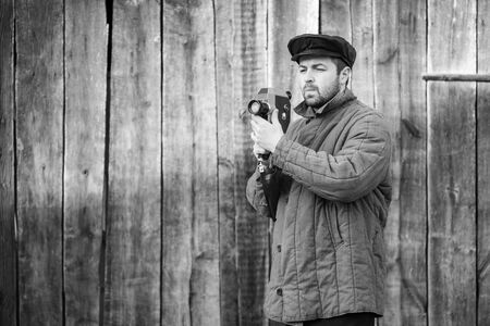 Cameraman with retro camera in his hands, monochrome effect. Concept - cinema industry, movie of 1970sの写真素材