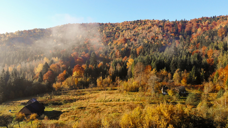 Old wooden huts in the valley of Carpathian Mountains, autumn landscape, morning timeの写真素材