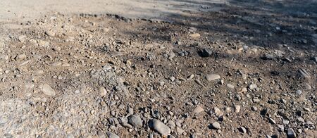 Destroyed asphalt cover on road. Bad road condition that needs repair. Banner size, top view. Theme of road construction and repair, selective focus, copy spaceの写真素材