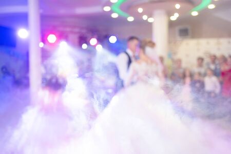 Abstract colorful blurry background. Newlyweds dance their first dance. Dance is decorated with light effects and smoke. Theme of shows organization services.の写真素材