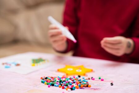 Colorful fusible beads or perler beads, on the children's table. Toy that develops the imagination of child. Soft blurred background with copy spaceの写真素材
