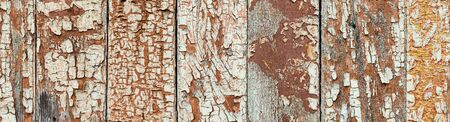 Rustic timber background with great texture, close up view. Cracked paint on wooden planks, aged by time. Super wide natural background with traces of wear, holes knots and seams, banner formatの写真素材