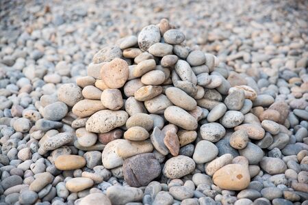 Heap of sea pebbles made by travelers on a seashore, close-up. Natural summer background with soft copy space. Summer time themeの写真素材