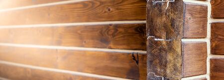 Wall of log house or log building close up. Theme of healthy housing, services of house construction from wooden logs, varnishing or putting. Wide-angle natural background with copyspaceの写真素材