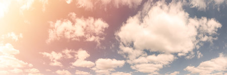 Beautiful landscape of blue cloudy sky with warm sunny tonings. Warm and soft sunlight illuminate...