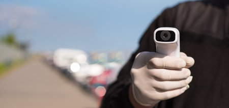 Inspector with a non-contact infrared thermometer in a public place. Digital medical tool for fast...
