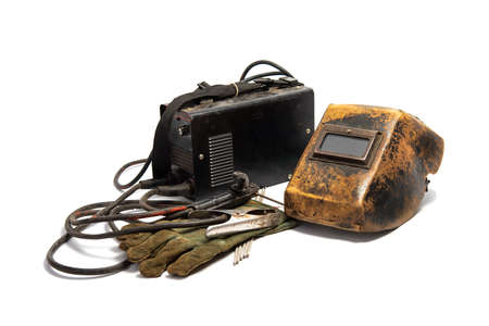 Welding mask with welding machine, protective gloves, and arc steel electrodes. Kit of used welding equipment on white backgroundの写真素材