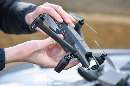 10 April 2022 - Krakow, Poland: Man performing battery replacement Drone Parrot ANAFI Thermal before fly.のeditorial素材