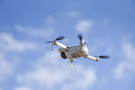 10 April 2022 - Krakow, Poland: Drone DJI Mavic Mini 2 flying in air, blue sky on background.のeditorial素材