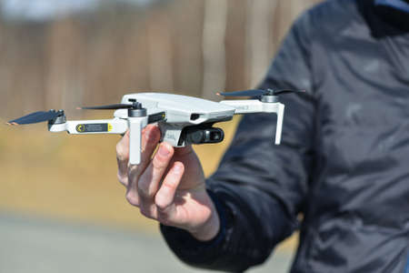 10 April 2022 - Krakow, Poland: Pilot holds the Drone DJI Mavic Mini 2 before flight. Quadcopter is ready to fly.のeditorial素材