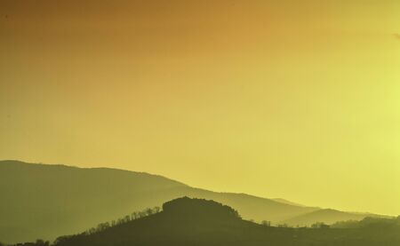 in yellow sunset and some hillsの写真素材