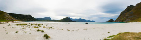 Panorama of Haukland beach on the Lofoten islands in cloudy weather. Mountains, sandy beach and azure water. Norway sea.の写真素材