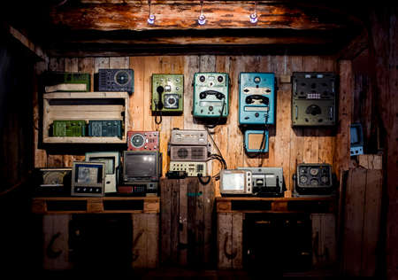 Retro devices on a wooden wall. Vintage measuring tools in a barn. Old phones.の写真素材
