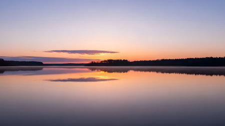 A breathtaking view of a calm lake perfectly reflecting the vibrant pastel colors of the sunrise or sunset sky. The still water mirrors the clouds and horizon, creating a peaceful and symmetrical natural landscape.の素材