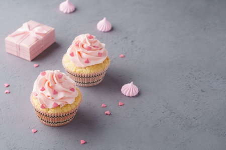 Pink cupcakes with heart shaped candy and gift box for Valentine's Day or wedding.