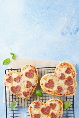 Heart shaped mini pizza with pepperoni. Valentines day romantic menu concept for restaurant or delivery.の写真素材