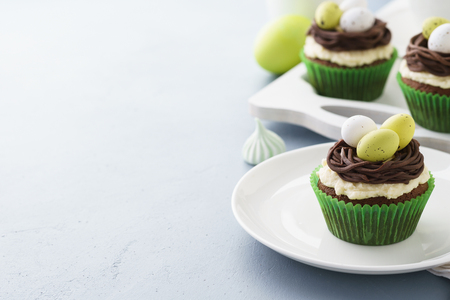 Easter chocolate cupcakes decorated with nest and eggs for dessert. Copy space.の写真素材