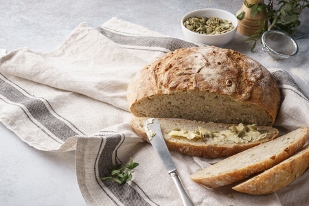 Whole grain bread and slice with butter and seeds for breakfast.の写真素材