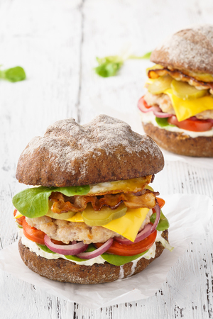 Chicken cheeseburger with bacon, lettuce, tomato and mayonnaise sauce for lunch.の写真素材