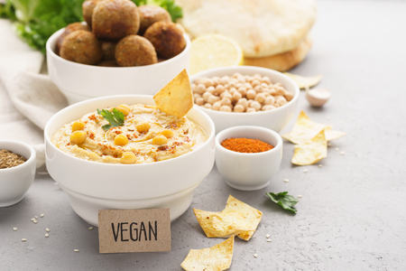 Hummus dip served with chips, pita and falafel. Vegan tag. Healthy food.の写真素材
