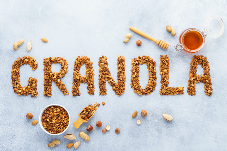 Healthy oat, nuts and honey granola background. Word granola made of baked oats.の写真素材