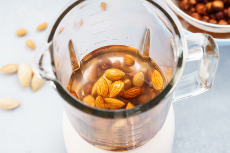 Blender with soaked almonds for making nut milk. Dairy free, no lactose vegan milk.