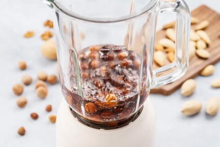 Blender with soaked hazelnuts for making nut milk. Dairy free, no lactose vegan milk. Step by step recipe.の写真素材