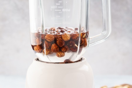 Soaked hazelnuts in blender. Making vegan nut milk. Lactose free. Step by step recipe.の写真素材
