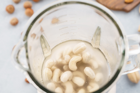 Blender with soaked cashews for making nut milk. Dairy free, no lactose vegan milk.の写真素材