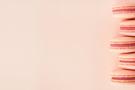Row of pink macarons on same color background. Creative monochrome mockup with copy space.