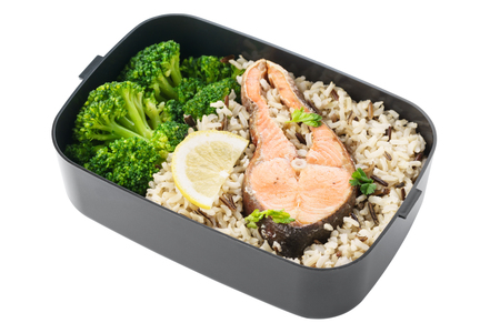 Healthy and nutritious lunch box with brown rice, broccoli and salmon. Ready to go for work or school. Isolated.の写真素材