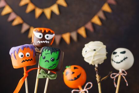 Halloween cake pops with funny monster faces. Festive treats concept with copyspace. Selective focus.の写真素材