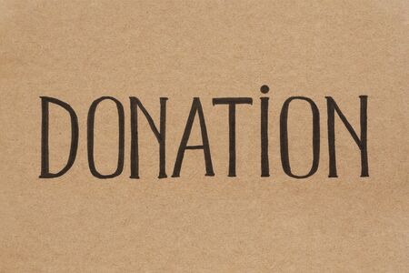 Word DONATION written by hand on cardboard. Handwritten lettering.の写真素材