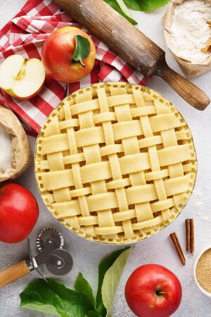 Making apple pie with lattice top. Raw unbaked apple pie with tools and ingredients for cooking.の写真素材