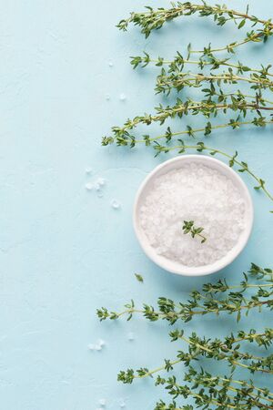 Coarse sea salt and fresh thyme on light blue background. Herbs and spices for cooking. Meat and poultry seasoning.の写真素材