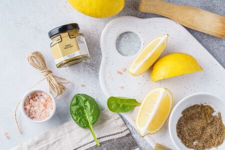 Set of ingredients for meat, fish or poultry cooking. Lemon, honey mustard, salt and pepper overhead shot.の写真素材