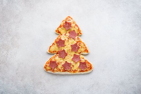 Pizza shaped as Christmas tree decorated with stars made of pepperoni. Pizza delivery advertising. Festive Xmas snack idea.の写真素材