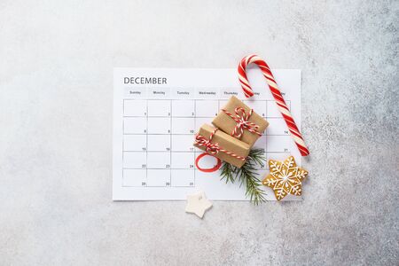 Planner page with Christmas gift boxes, cookies and decoration on light gray background. 25th of December marked with red circle on calendar. Xmas preparation concept. Copy space.の写真素材