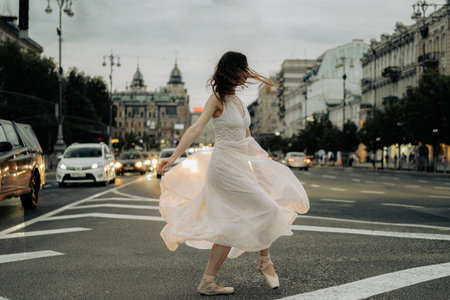 A woman in a flowing dress dances gracefully in the middle of a city street, bringing movement and life to the urban setting. May 18, 2024, Kyiv, Khreshchatyk streetのeditorial素材