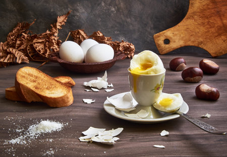 Breakfast still life. Boiled soft-boiled egg on a stand with a spoon, with slices of toast bread,...