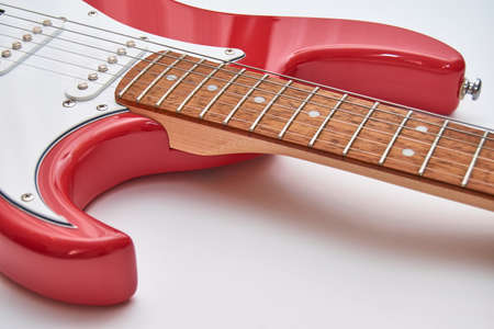 Fragment of a red electric guitar on a white background. Part of the guitar. Music object.の写真素材
