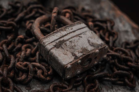 Old padlock on a rusty chain close-up. The concept of protection, safety, security.の写真素材
