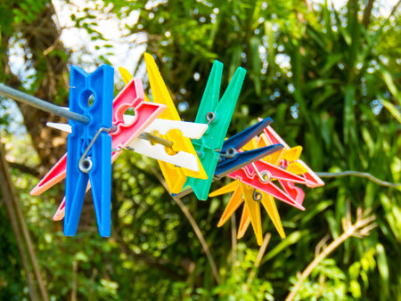 colored pegs hanging by a threadの写真素材